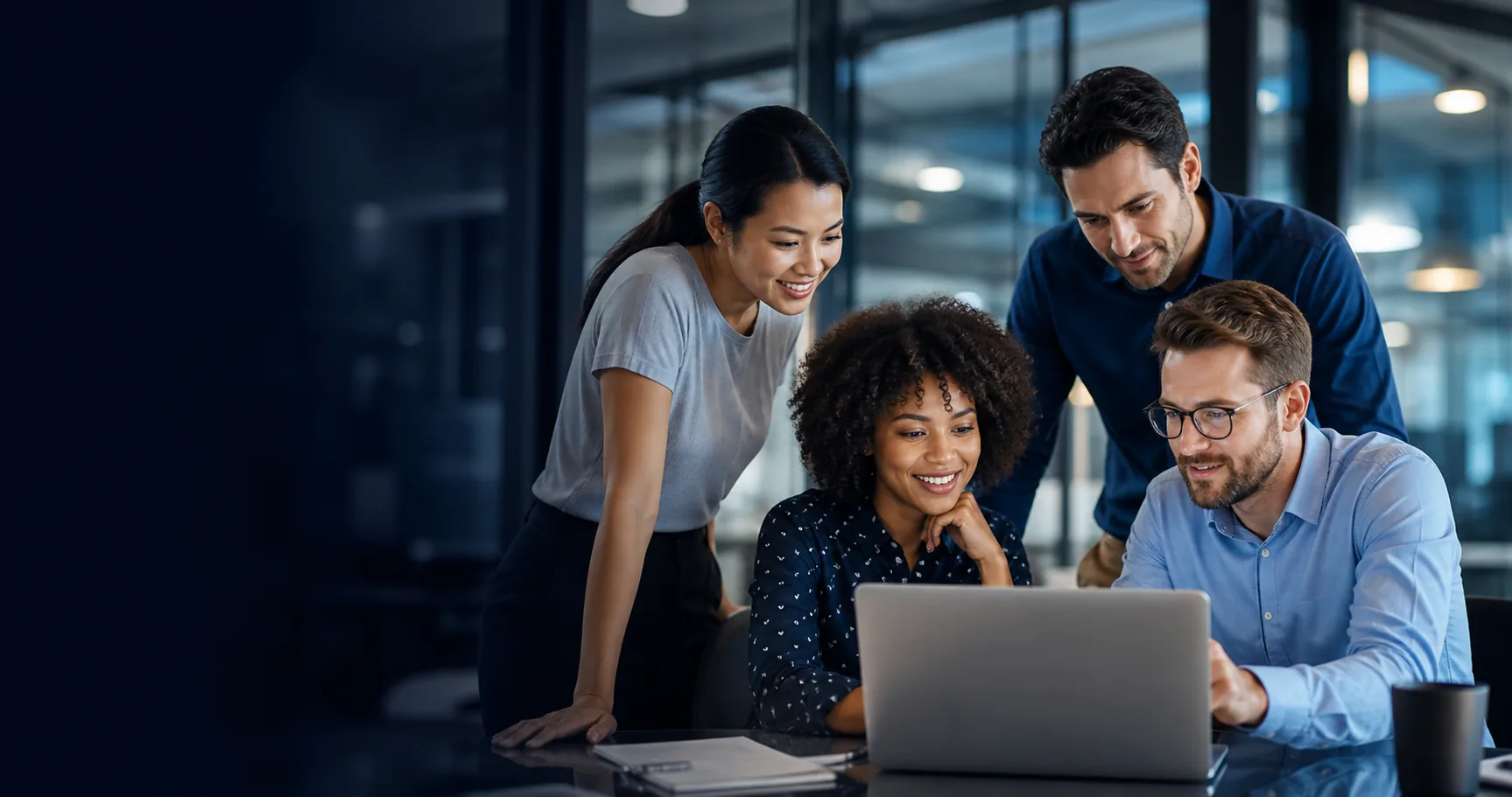 Technology professionals collaborating around a laptop
